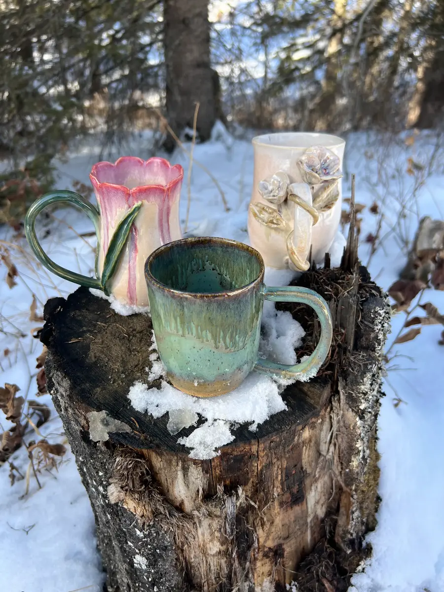 A collection nof handmade pottery mugs.