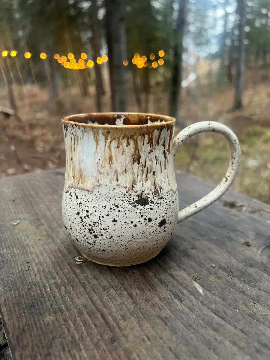 A brown and white, handcrafted pottery mug.
