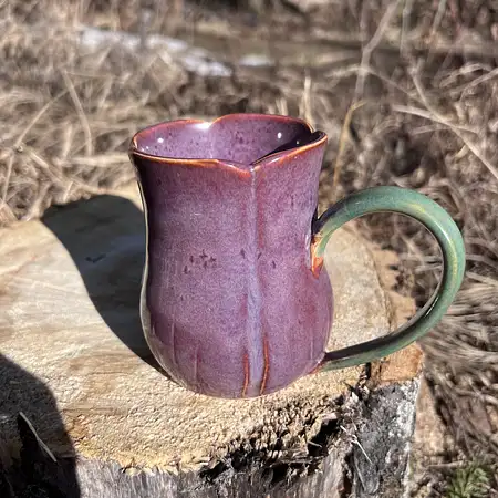Hand thrown carved tulip cup with purple and green glazes. 
