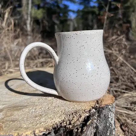 Hand thrown cup dipped in a simple white glaze, making the speckled clay the star of the show. 