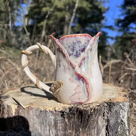 Wheel thrown cup with sculpted clay creating a purple hue rosebud cup. 