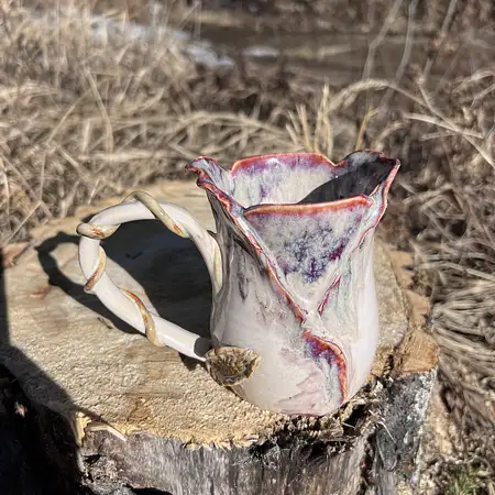 Wheel thrown cup with sculpted clay creating a purple hue rosebud cup. 