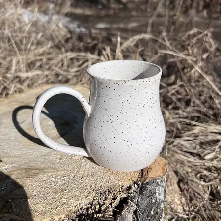 Hand thrown cup dipped in a simple white glaze, making the speckled clay the star of the show. 