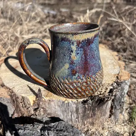Hand carved wide bottom mug dipped in an earthy blue/brown glaze.
