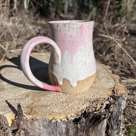 Hand thrown cup featuring speckled clay with a white and pink drippy glaze.