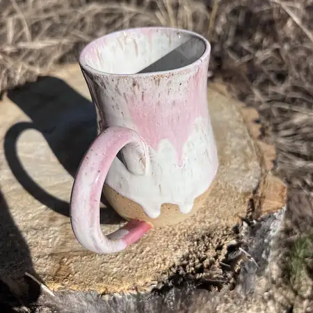 Hand thrown cup featuring speckled clay with a white and pink drippy glaze.
