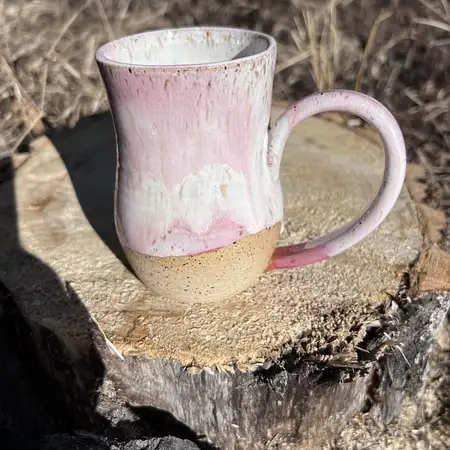 Hand thrown cup featuring speckled clay with a white and pink drippy glaze.