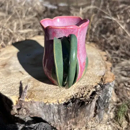 Hand thrown bright pink tulip cup featuring a stem and leaf handle.