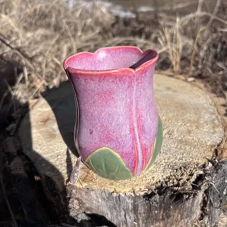 Hand thrown bright pink tulip cup featuring a stem and leaf handle.