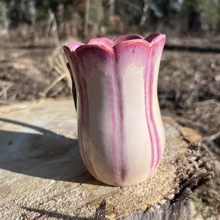 Hand thrown, carved and sculpted tulip cup featuring a scallop rim, stem and leaf and pink and white glaze. 