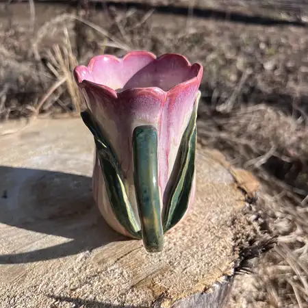 Hand thrown, carved and sculpted tulip cup featuring a scallop rim, stem and leaf and pink and white glaze. 