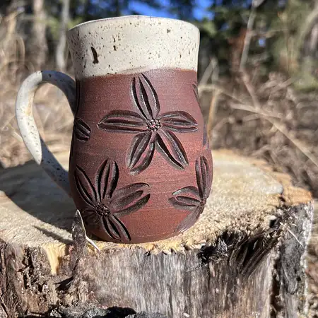 Hand carved floral cup in raw brown clay with a woodsy glaze. Medium sized coffee mug. 