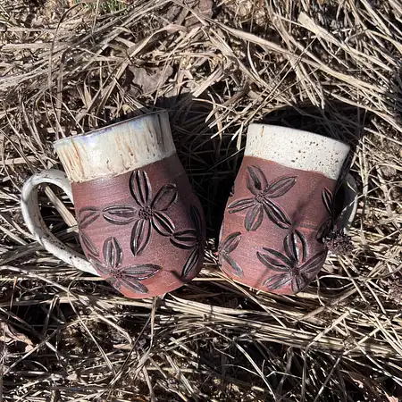 Hand carved floral cup in raw brown clay with a woodsy glaze. Medium sized coffee mug. 