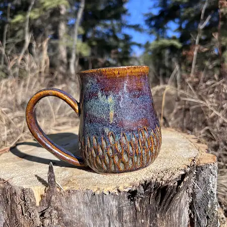 Hand carved wide bottomed mug dipped in a combination of earthy brown and blue glazes.