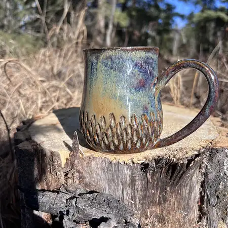Hand carved wide bottomed mug dipped in a combination of earthy brown and blue glazes.