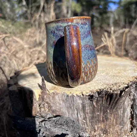 Hand carved wide bottomed mug dipped in a combination of earthy brown and blue glazes.